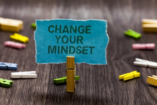 I piece of paper held up by a clothes pin that read 'CHANGE YOUR MINDSET