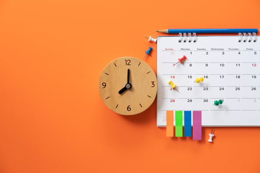 The concept of deadline: A calendar with pins and sticky notes on it, along with a clock that shows the time of 8:00