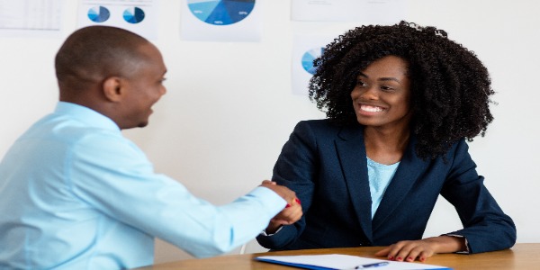 Women shaking hands with man.