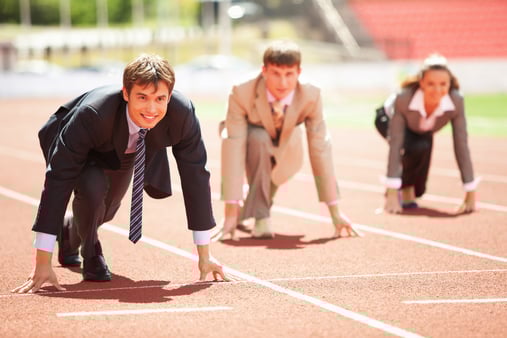 Businesspeople on a running track in their business suits