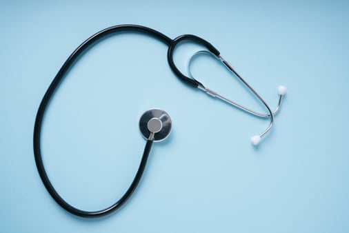 The concept of health and FSAs. A stethoscope on a light blue background. 