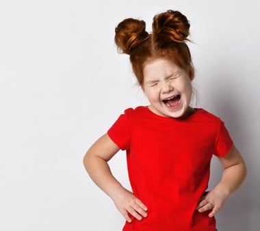 Little girl with hands on her hips and screaming loudly 