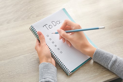 person writing to do list