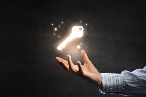 Hand with a magically floating, glowing key above it