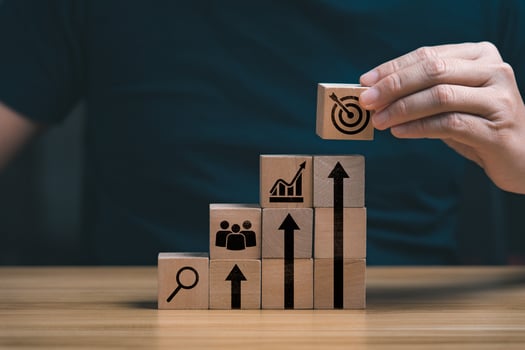 Someone stacking blocks that lead to growth
