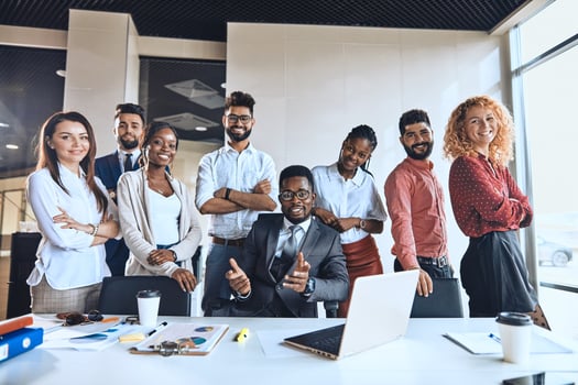 Employees posing behind a meeting table