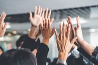 A team of people raising their hands