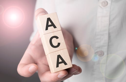 A hand holding three letter blocks: A, C, and A 