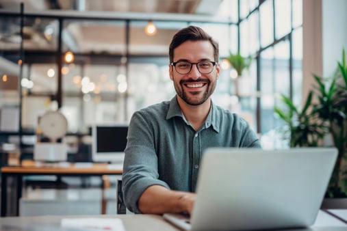 Businessman sitting at computer and smiling 