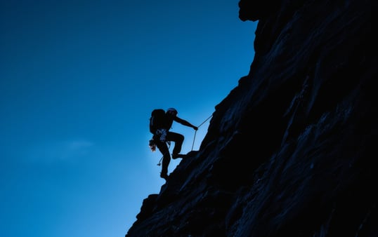 Concept of willpower. A climber climbing a seemingly never-ending mountain, determined to succeed. 