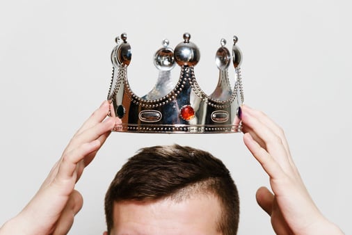 Man putting a crown on top of his head