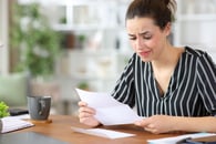 An employee or employer who is staring at a piece of paper and looks worried 