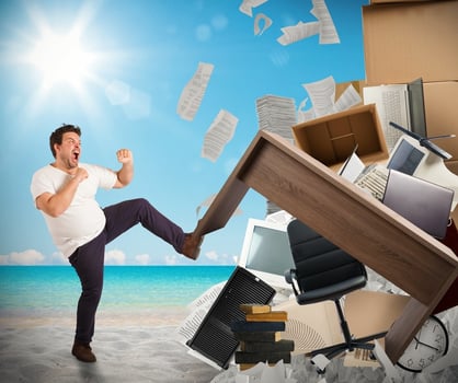 A man karate-kicking an office desk 