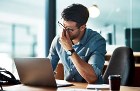 A frustrated businessperson sitting at their desk. 
