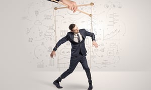Little businessman controlled from above like a puppet