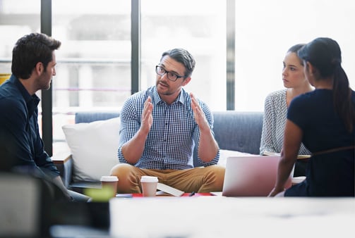 Business man mentoring a team in a casual seating setting