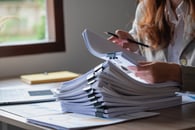 The concept of keeping up with compliance. A businessperson reviewing documents. 