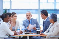 People sitting around a table, drinking water and talking