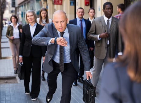 Stressed businessman checking his watch and running 