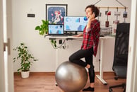 Young woman in plaid shirt standing at a remote work station 