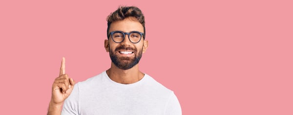 Smiling guy pointing a single finger up, displaying #1