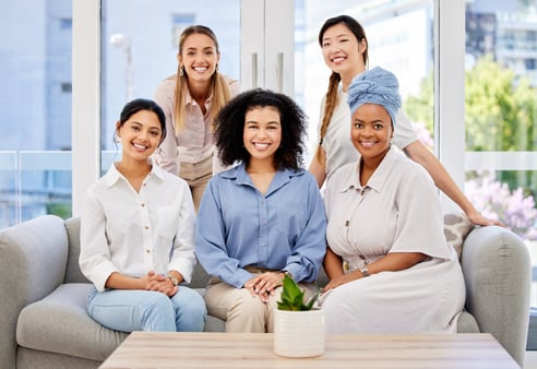 A group of diverse women posing and smiling for a picture 