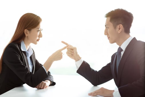 Two people pointing at each other 