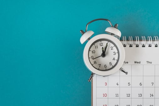 Alarm clock and calendar on a blue background; concept of reminder
