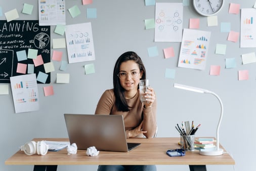 A female entrepreneur at her desk, the concept of the myth of doing it all herself 