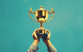 Two hands holding up a trophy 