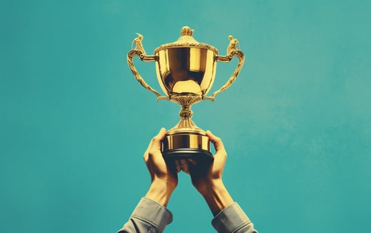 Two hands holding up a trophy 