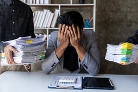 The concept of chaos. A businessperson getting overwhelmed by documents and tasks. 