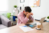 A salesperson with his head in his hand and stressed out over a situation