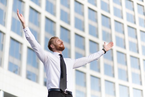 The concept of motivation. A businessperson with his hands in the air in victory. 