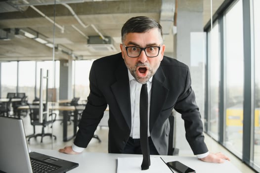 Angry business man yelling across a desk