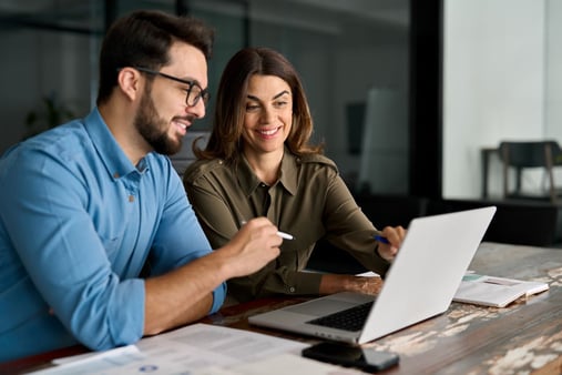 Man and woman sitting looking at a computer