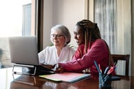 A younger businessperson learning from an older businessperson
