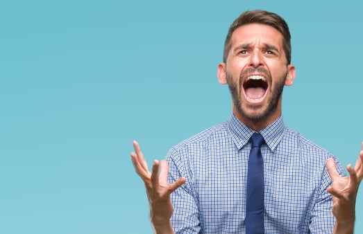 Frustrated man in business shirt and tie yelling with hands up