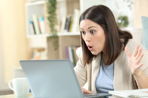 Woman looking at her computer screen in shock
