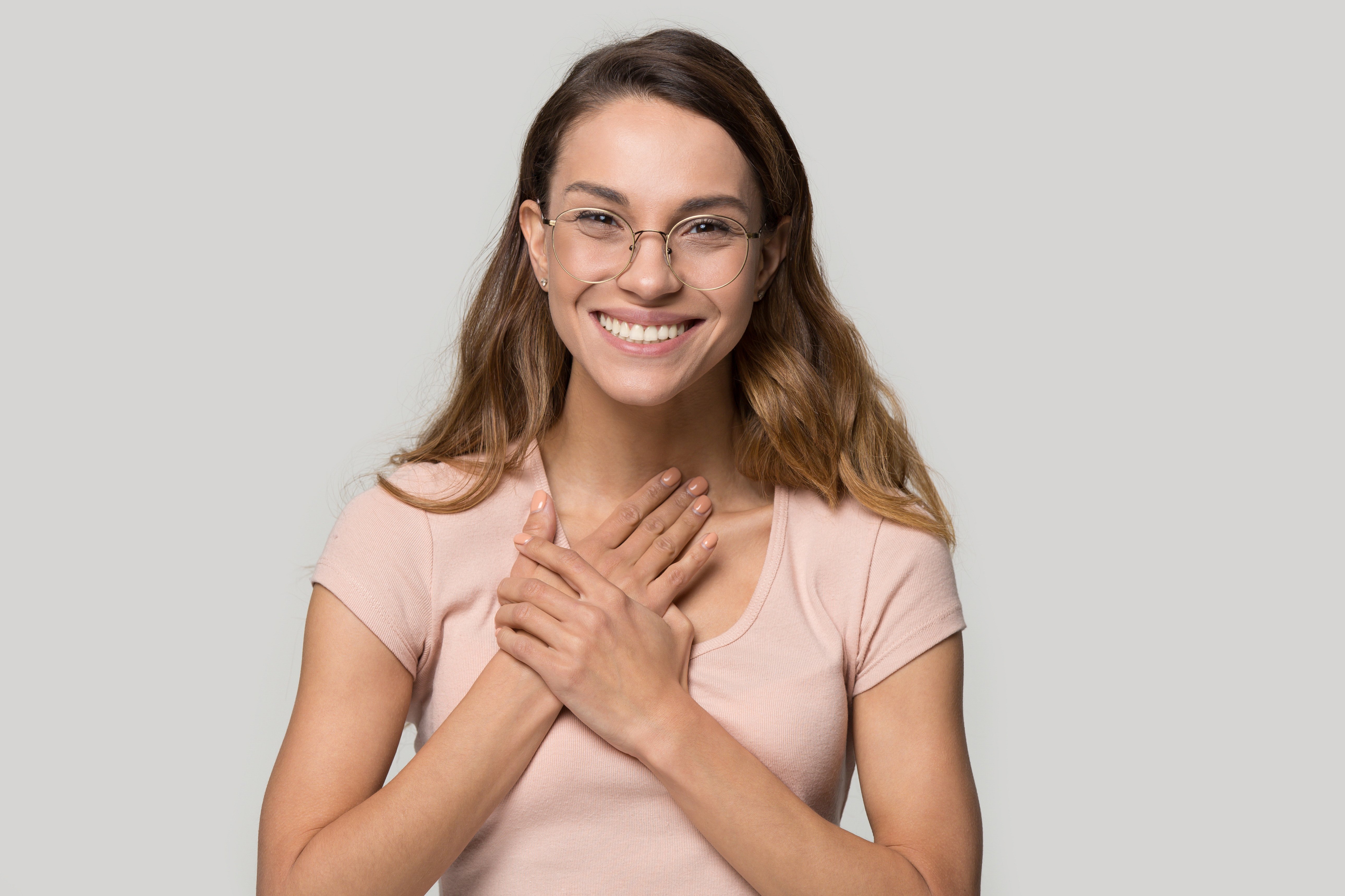 Women smiling, holding hand to chest