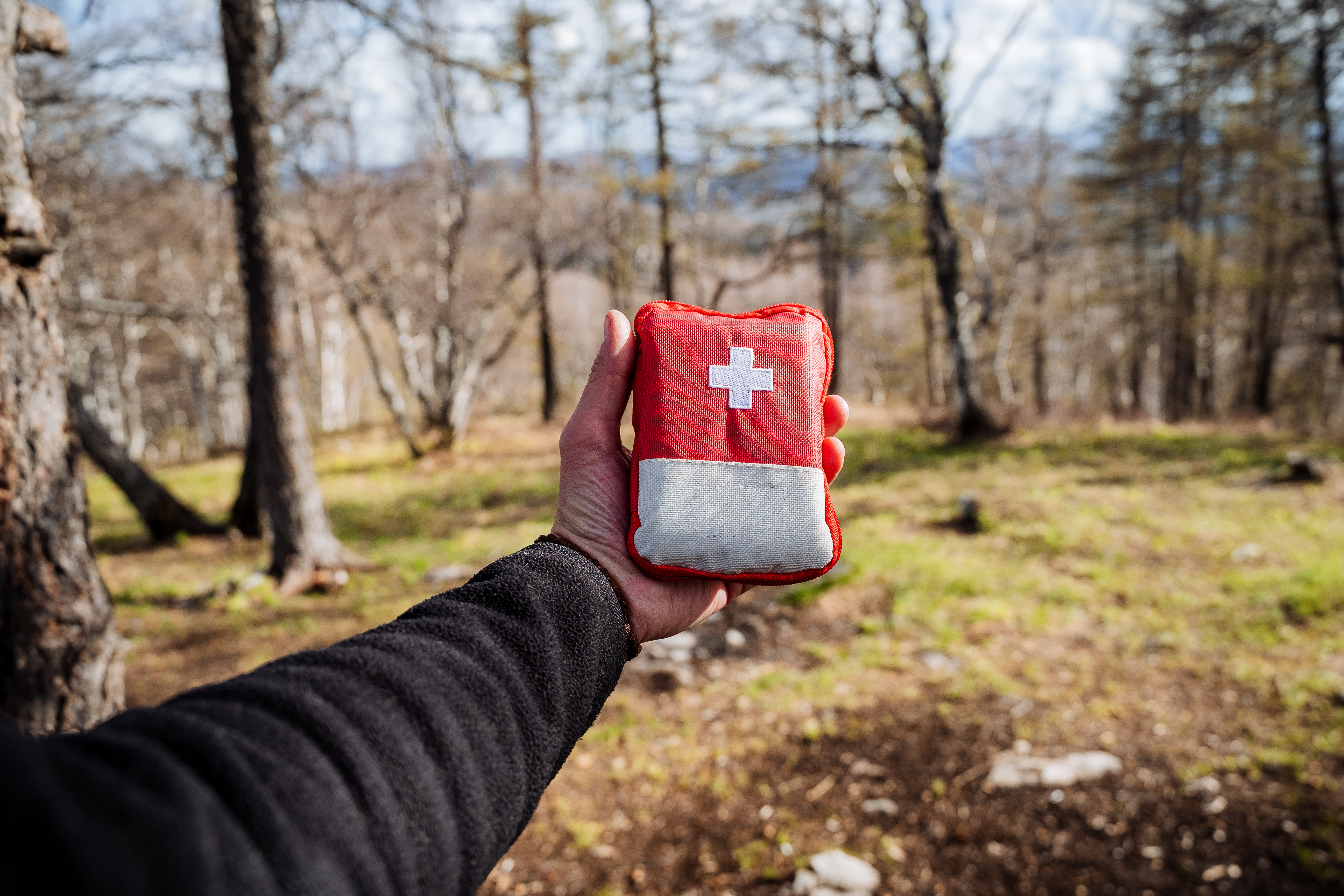 Person in the woods holding a medical bag