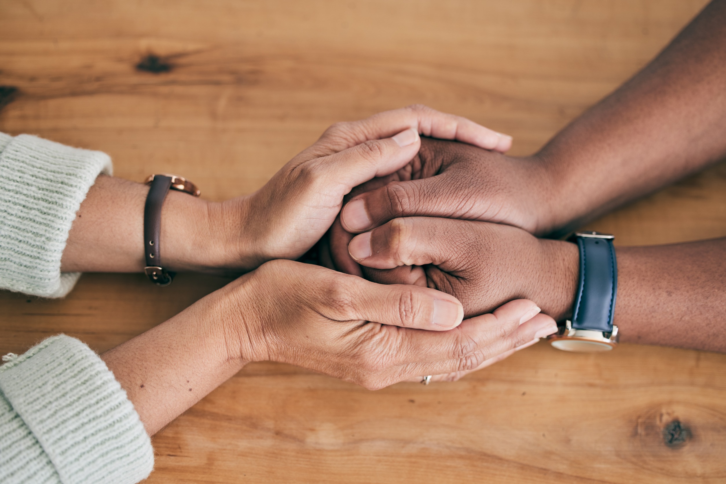 Two people holding hands and supporting one another 