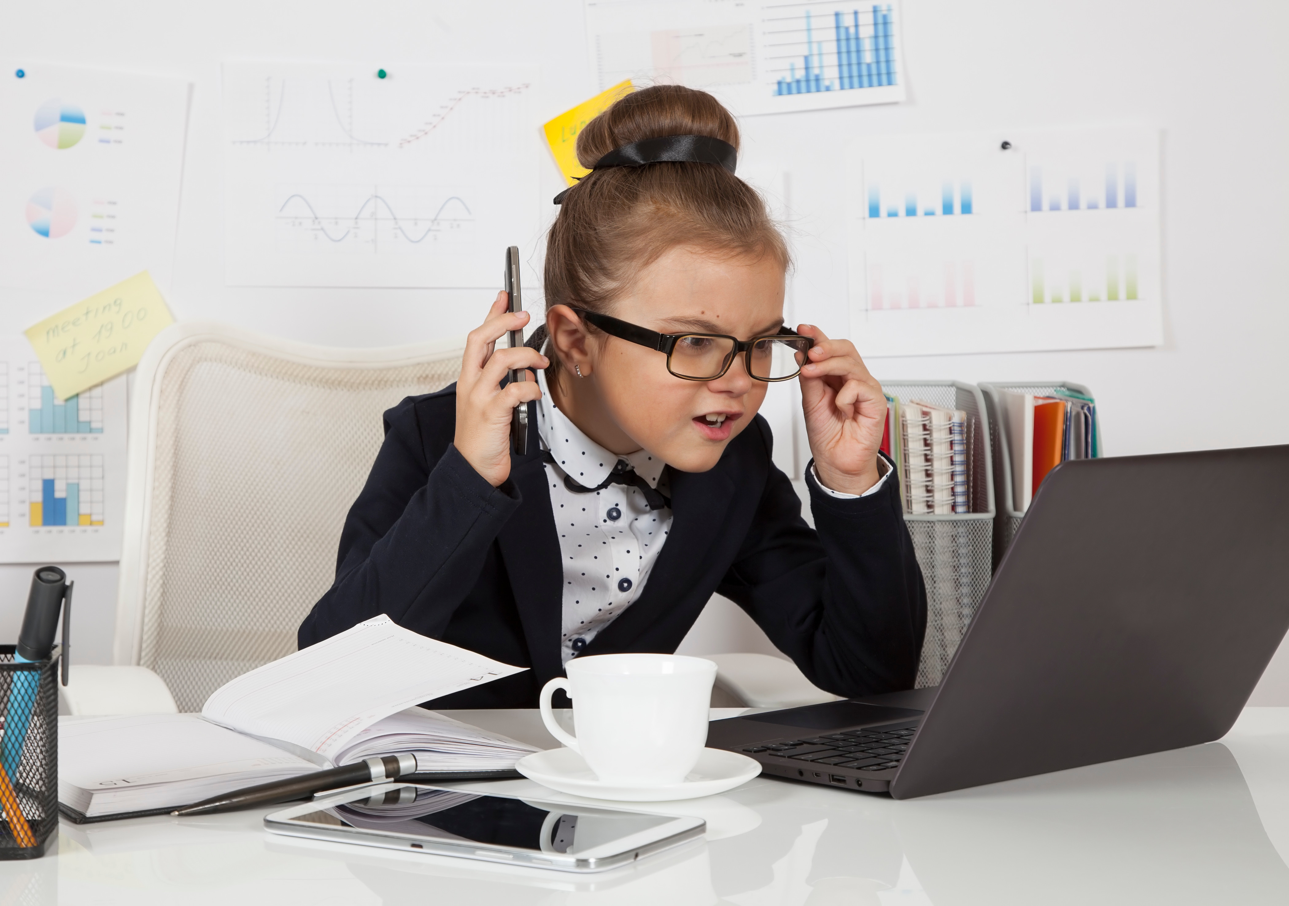 Child looking at computer wearing business clothes. 
