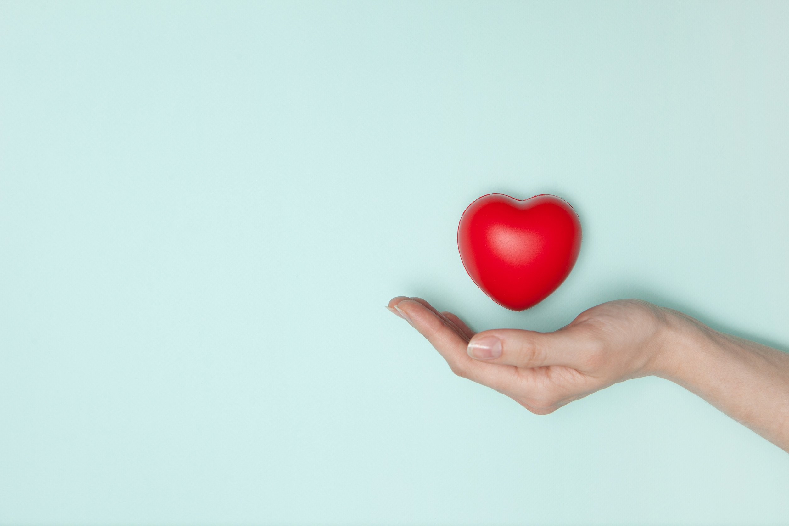 The concept of client experience. A hand holding a heart to symbolize the heart of client experience. 