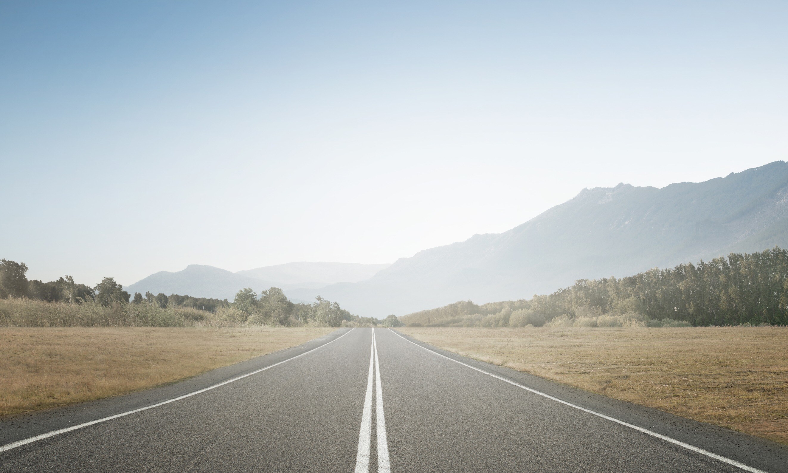 Concept of straight and steady progress over time. A road leading into the distance. 