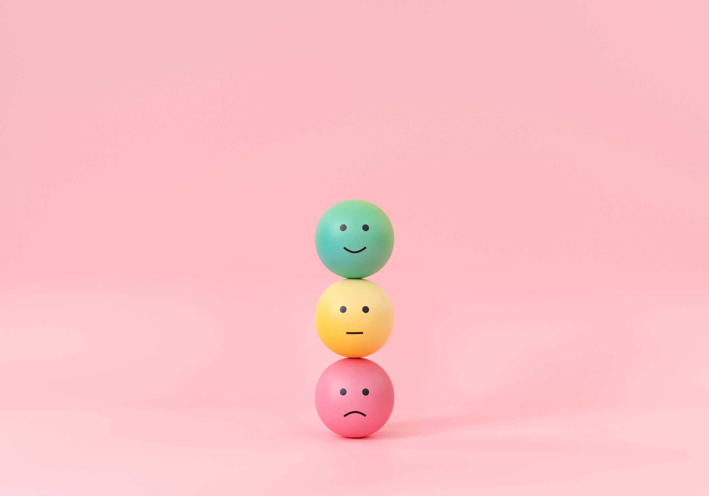 Three balls balanced on top of each other with various emotions on them 