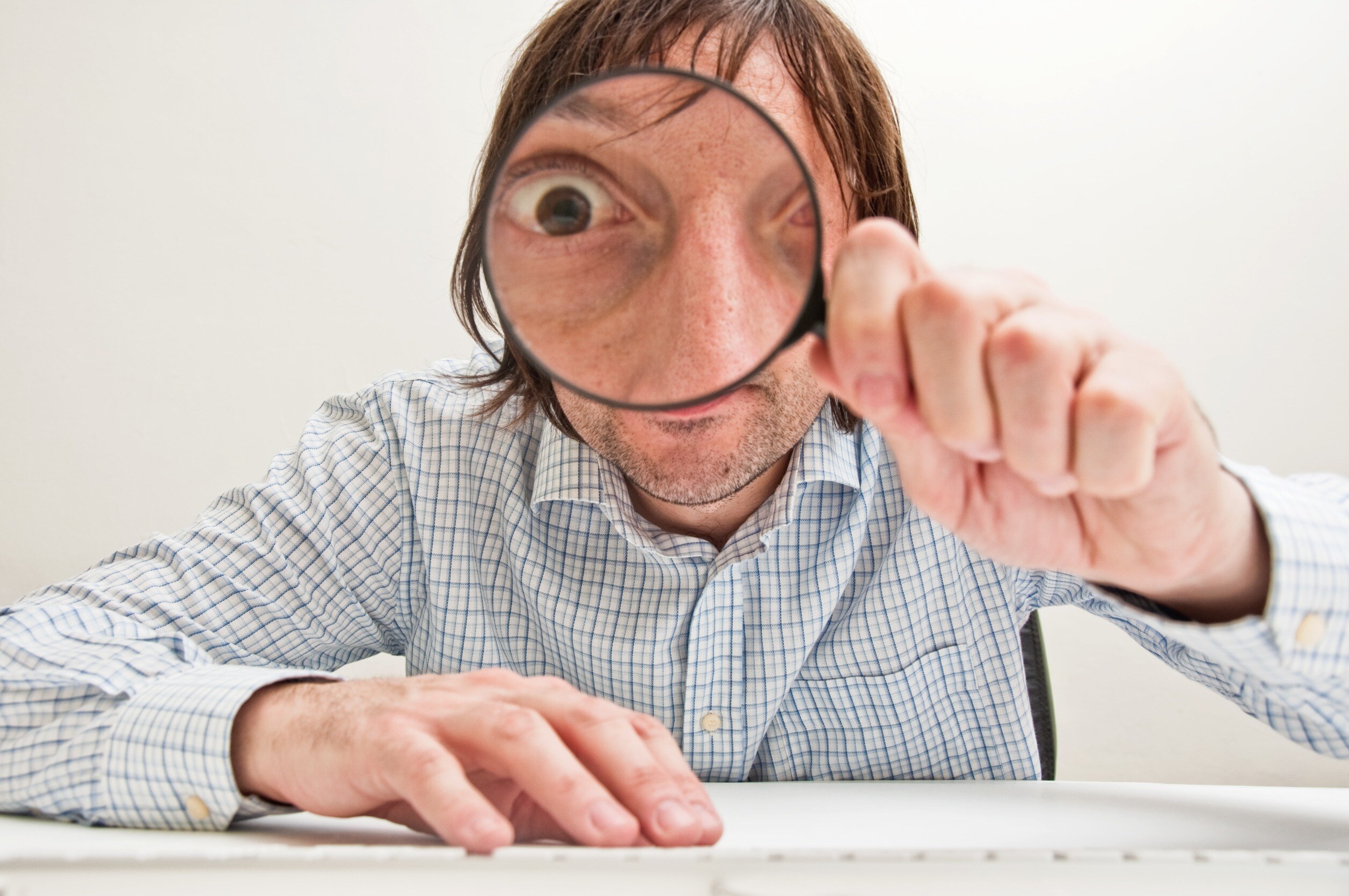 A man looking through a magnifying glass 